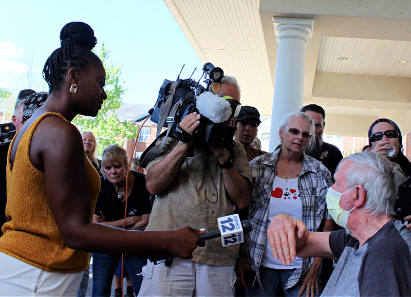 media talking to man in wheelchair