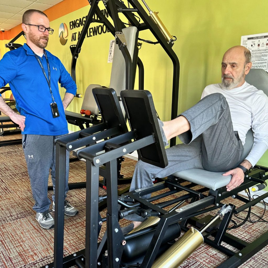 man with personal trainer in gym