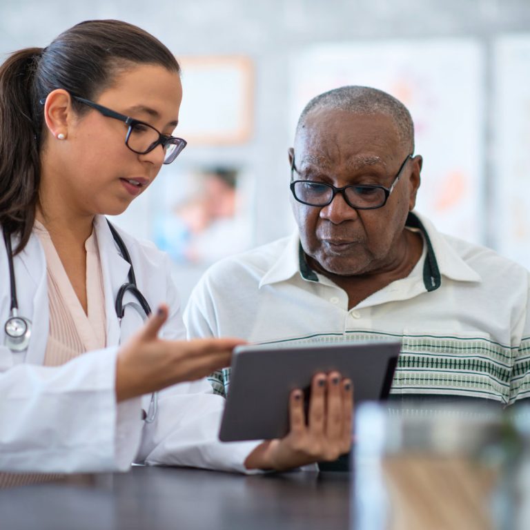 doctor holding tablet talking to patient