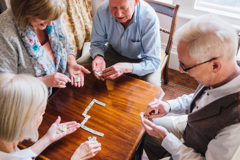 Four people playing dominos