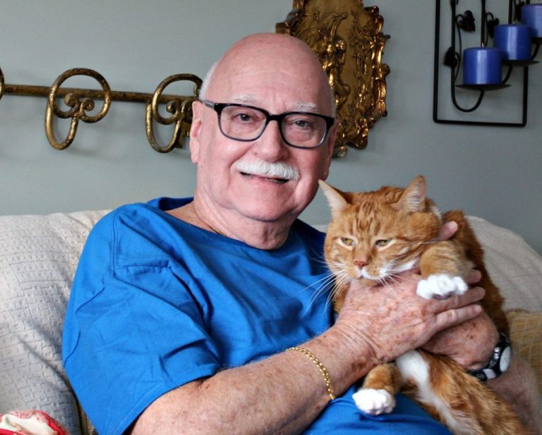 smiling man with large orange cat