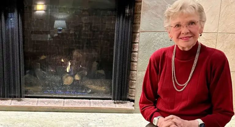 smiling woman in front of fireplace