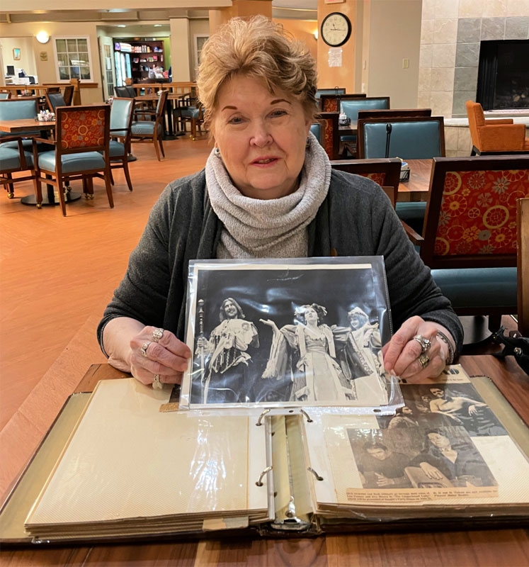 woman holding up picture from photo album