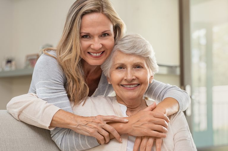 senior and adult daughter embracing