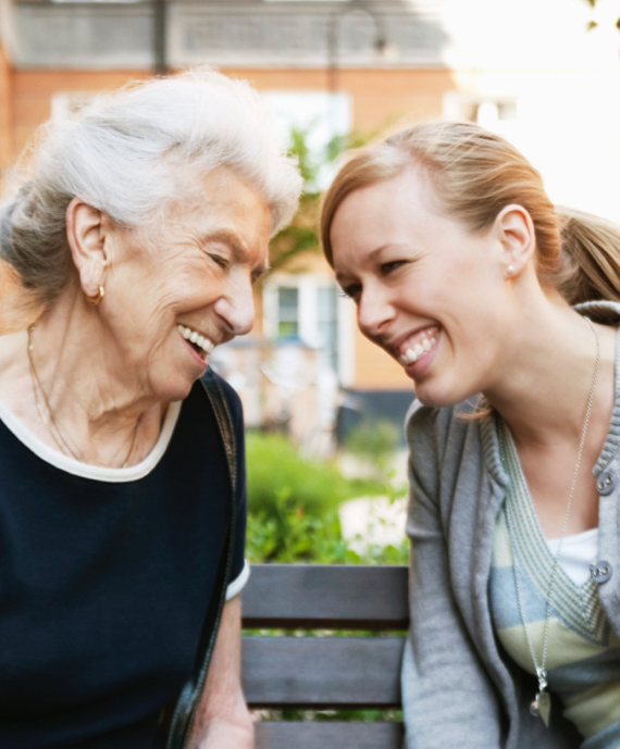 2 women smiling with heads together