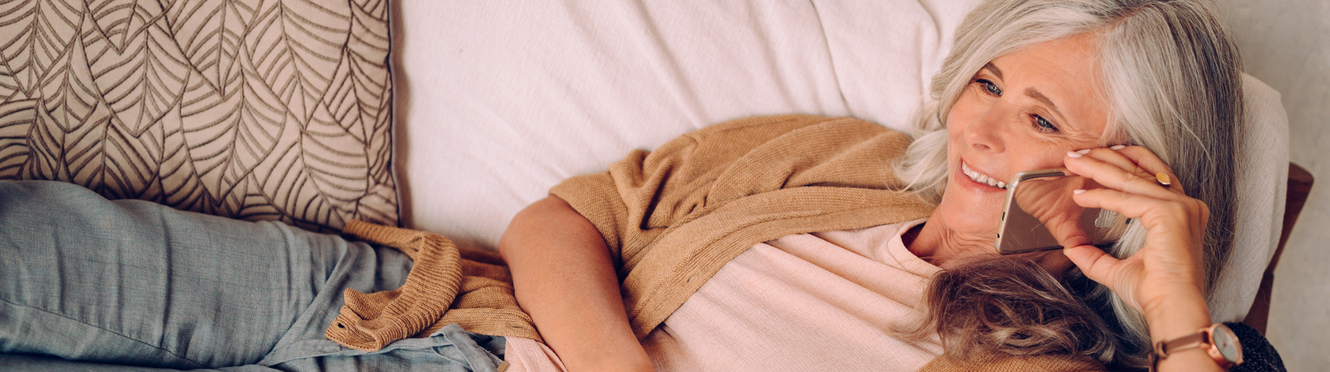 woman laying on couch talking on phone