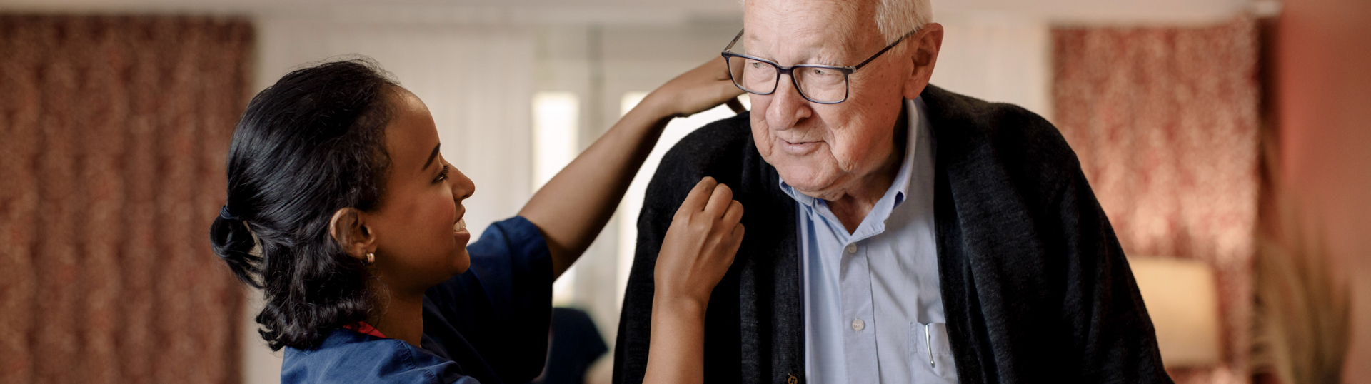 nurse helping man with his jacket