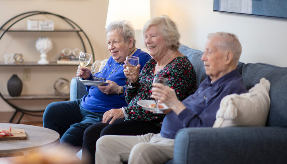 3 elderly people drinking wine on couch