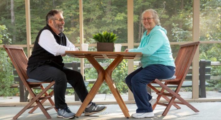 couple at wooden table, smiling