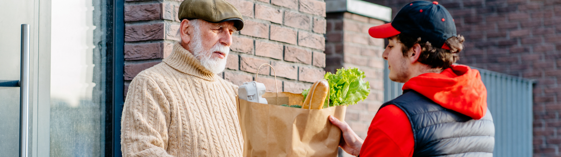 young man handing over back of groceries