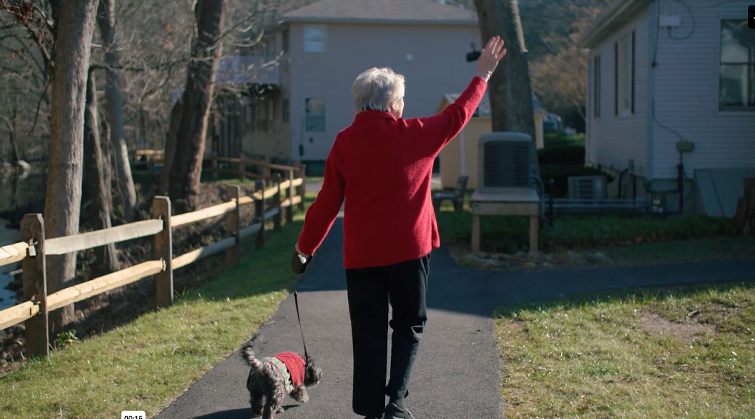 lady walking dog & waving