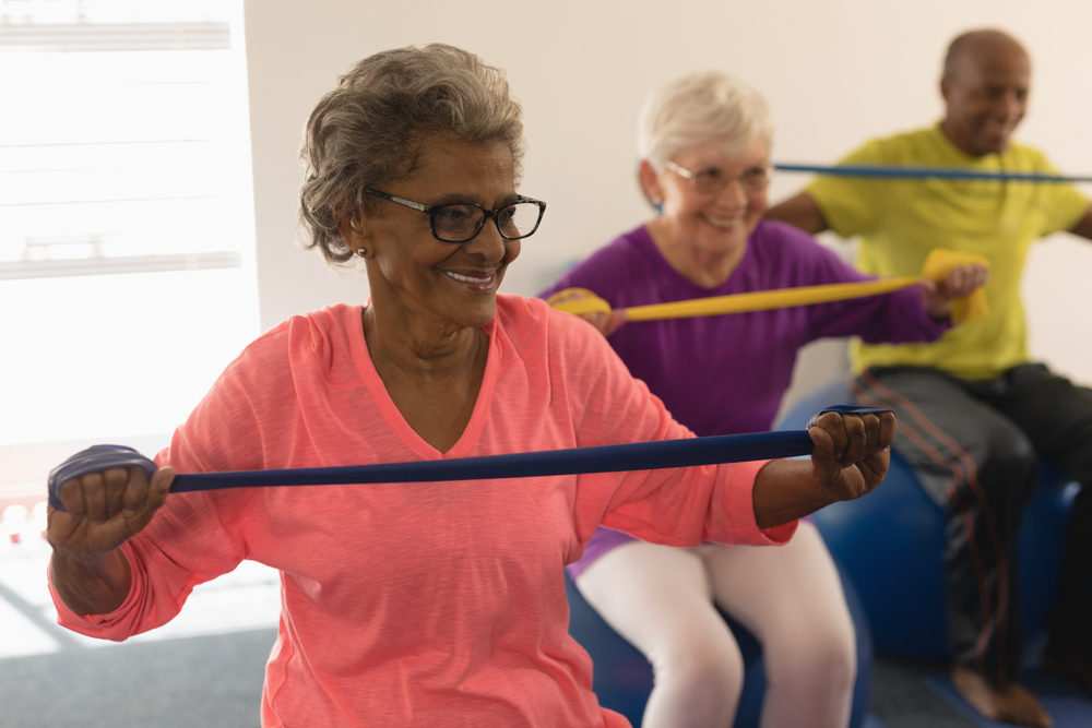 A group of seniors exercise with workout bands.