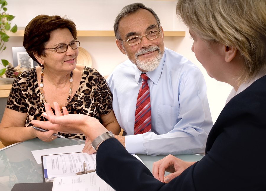 A senior man and woman sit down with a retirement planner.