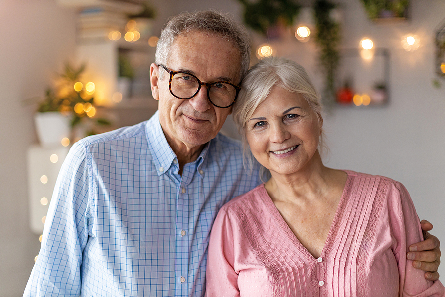 senior couple smiling in their decorated senior apartment