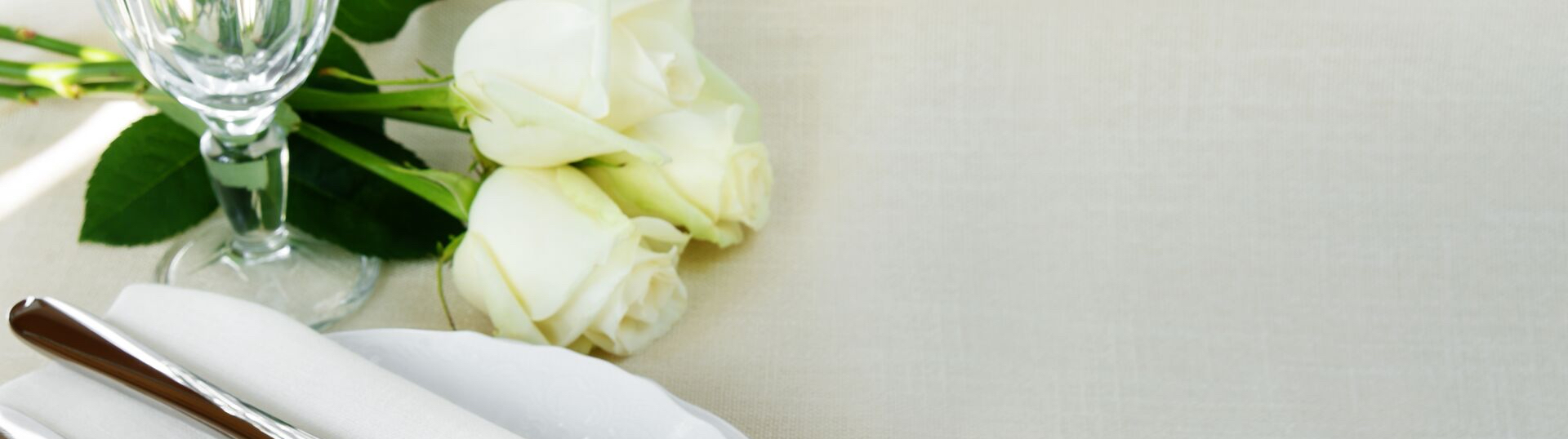 Close up of white roses near a dining place set 