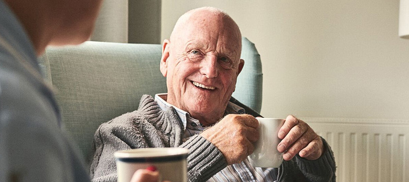 happy senior smiling while drinking coffee