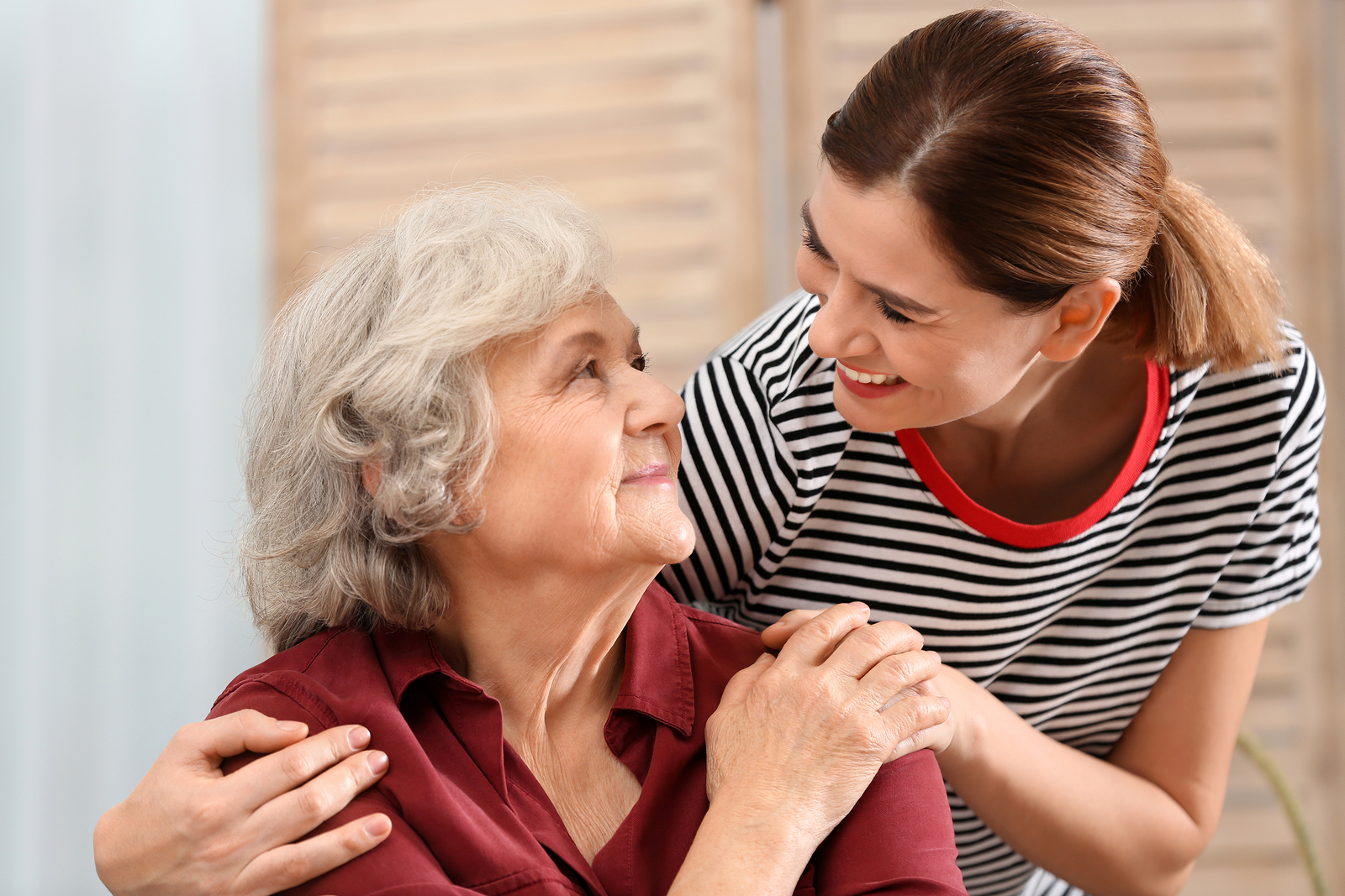 A woman hugs her elderly mother.