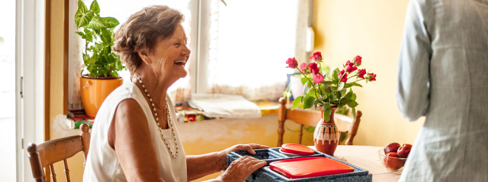 smiling senior sitting at a kitchen table