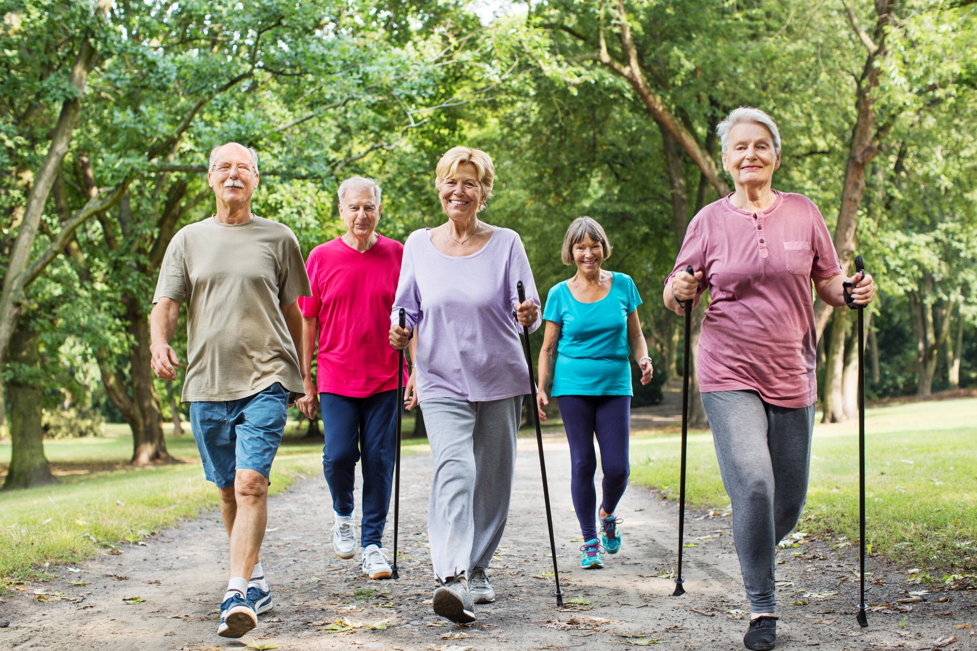 group of senior friends walking on a trail together