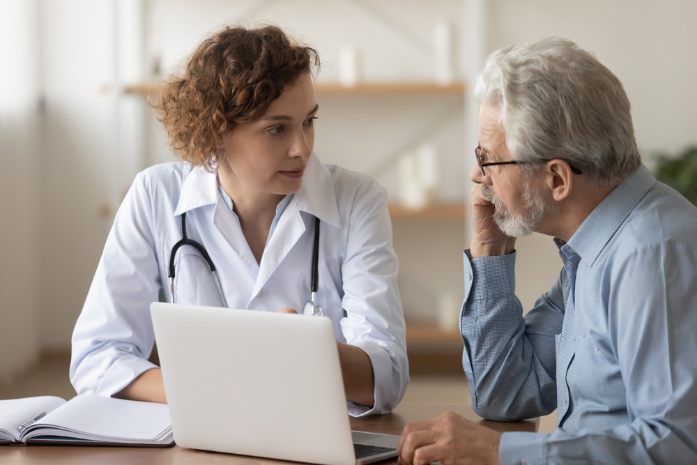 Senior man speaking with geriatrician.