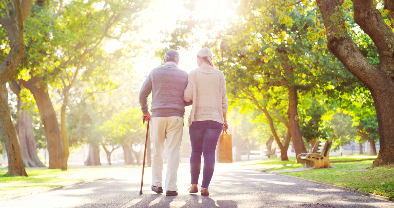 a caregiver walking with a resident in the sunshine