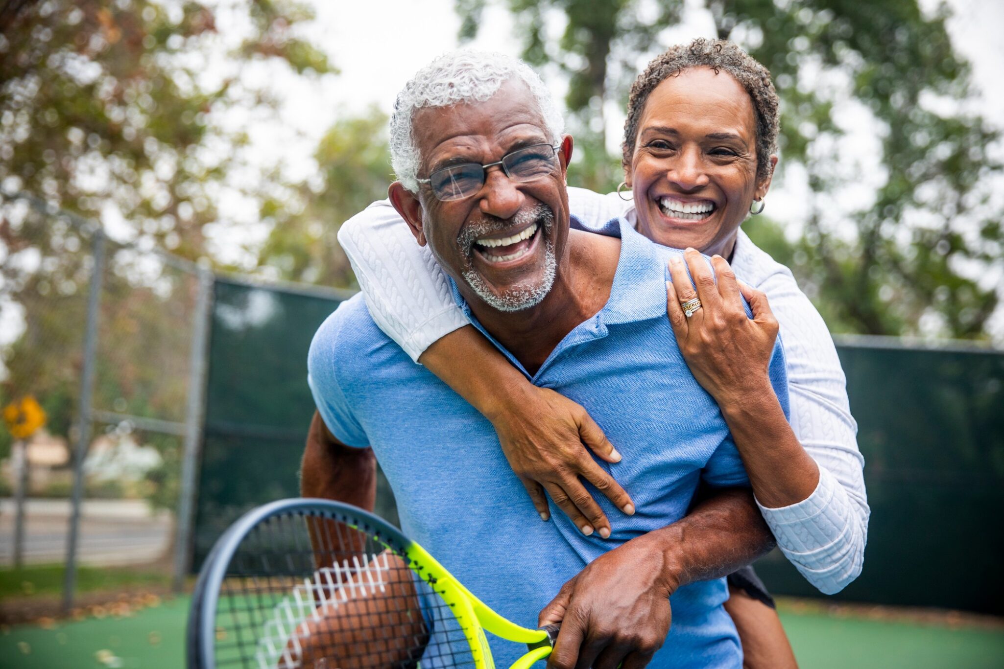 senior couple with tennis rackets