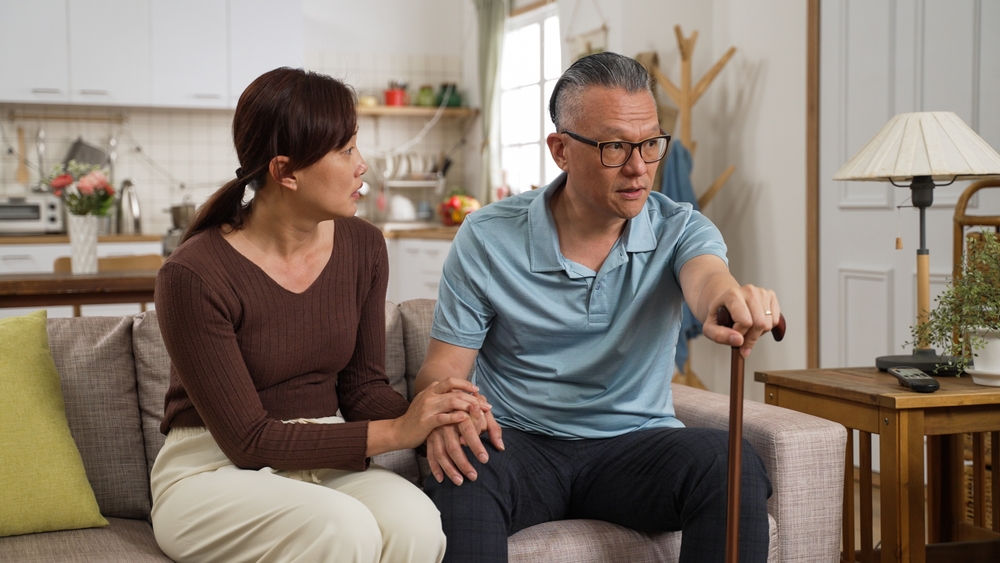 A daughter looks to her older father as he has a concerned look on his face