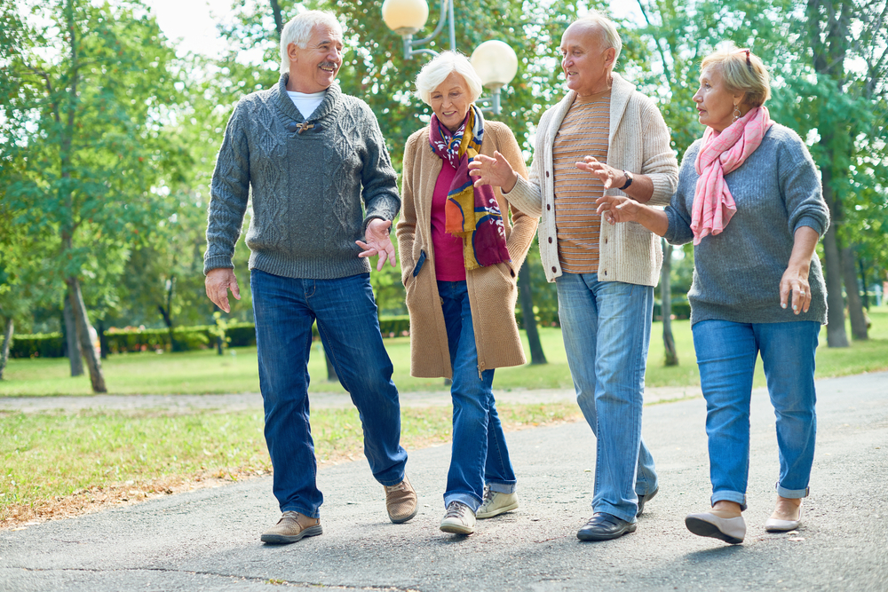 two senior couples walking on a trail