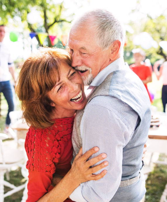 An energetic and happy senior couple dancing together.