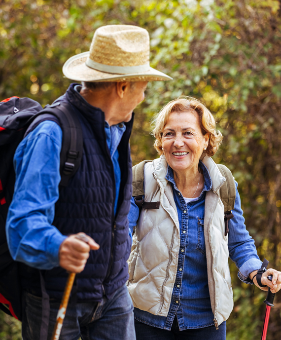 A senior couple hiking together in the woods.