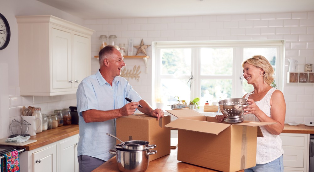 couple packing boxes in kitchen